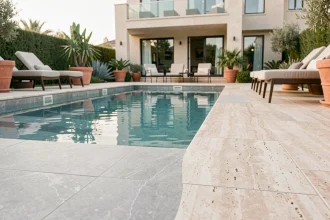 Revêtement en carrelage gris clair pour piscine familiale moderne avec terrasse en travertin