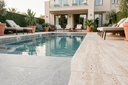 Revêtement en carrelage gris clair pour piscine familiale moderne avec terrasse en travertin