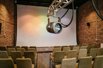 Projecteur PAR LED compact monté sur structure légère au-dessus d'une petite salle de conférence avec projection colorée sur cyclorama